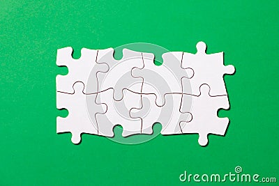 Eight pieces white jigsaw puzzle on green background for business presentation Stock Photo