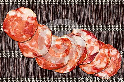 Eight Pork Salami Slices Set On Vintage Rustic Interlaced Parchment Place Mat Rough Grunge Surface Stock Photo