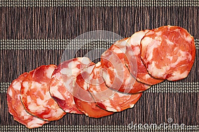 Eight Pork Salami Slices Set On Vintage Rustic Interlaced Parchment Place Mat Rough Grunge Surface Stock Photo