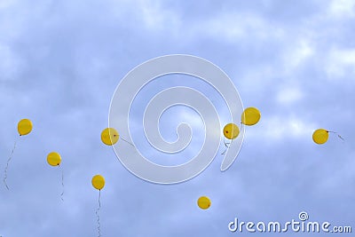 Eight yellow balloons against dark stormy sky Stock Photo