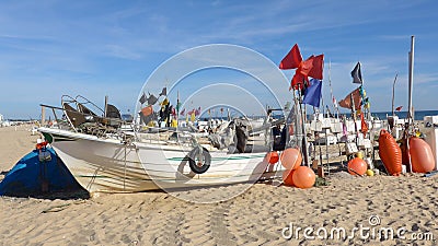 Fischerboot mit vielen Bojen auf dem langen, breiten, feinsandigen Strand von Montegordo, Algarve, Portugal Editorial Stock Photo