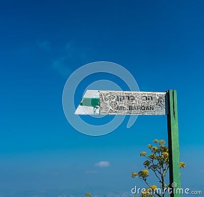 Weathered pointer to Mount Barqan against the blue sky. Israel Editorial Stock Photo