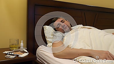 Ein kranker junger Mann in einem Bett stock footage Ein kranker junger Mann in einem Bett stock footage