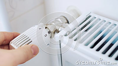 Ein Mann reguliert die Temperatur im Haus mit einem Thermostat auf dem Heizkörper stock video footage Ein Mann reguliert die Temperatur im Haus mit einem Thermostat auf dem Heizkörper stock video footage