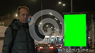 Ein Mann spricht am Telefon nachts in der Stadt Ein Smartphone ist Kommunikationsmittel Gegen den Hintergrund stock video footage Ein Mann spricht am Telefon nachts in der Stadt Ein Smartphone ist Kommunikationsmittel Gegen den Hintergrund stock video footage