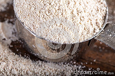 Einkorn siyez whole wheat flour in metal measuring cup on natural background Stock Photo