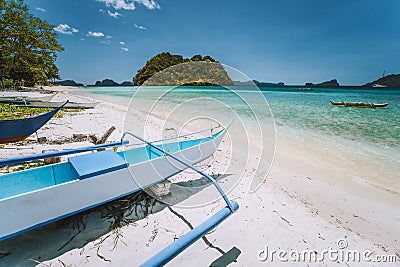 El Nido, Palawan, Philippines. White banca boat at Las cabanas beach with tropical island in background. Beautiful Stock Photo
