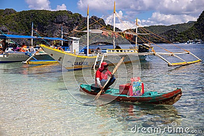 El Nido, Philippines - 20 Nov 2018: sea landscape with tourist boat and food seller in kayak. Streetfood vendor on beach Editorial Stock Photo