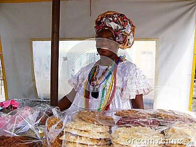 El Salvador, Brazil. November-11 th 2016. Brazilian woman of African descent wearing traditional clothes sells cookies Editorial Stock Photo
