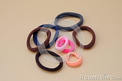 Elastic bands for hair of different colors on a beige background. Stock Photo