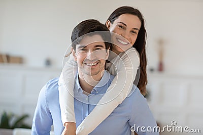 Elder brother student piggybacking teenage sister posing for cute picture Stock Photo