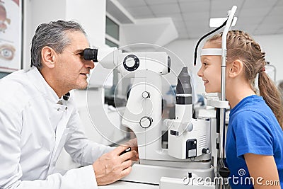 Elder doctor working and testing vision with slit lamp Stock Photo