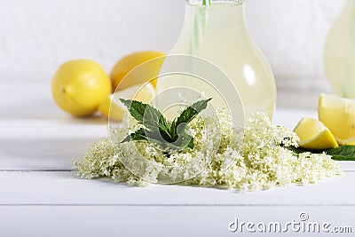 Elder lemonade - healthy and refreshing summer drink. Close up of homemade elderflower syrup in a bottle with elderflowers. Summer Stock Photo