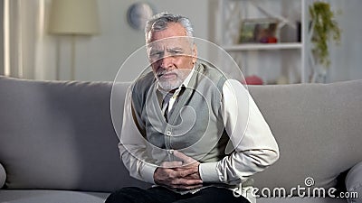 Elder male suffering stomach ache, sharp cramps in upper abdomen, indigestion Stock Photo