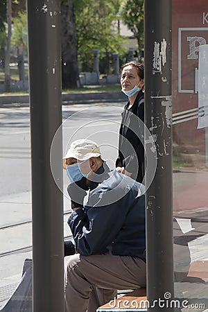 Elder people wearing face surgical masks waiting at bus stop Editorial Stock Photo