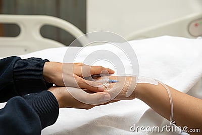 Elder senior hold woman patient hand sleeping on bed in hospital room Stock Photo