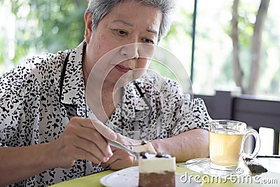 Elder senoir eating chocolate mousse cake at cafe. elderly woman Stock Photo