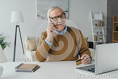 Elder smiling man working in office and making Stock Photo