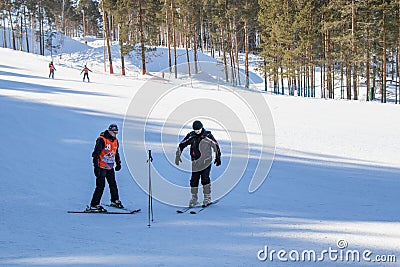 A elder trainer teaches a man skiing Editorial Stock Photo