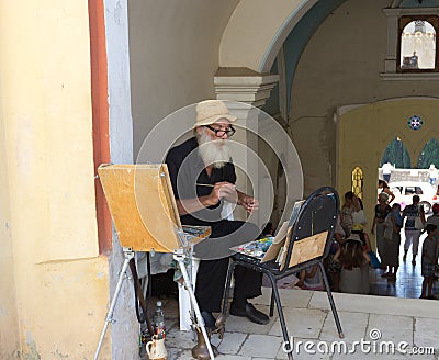 An elderly artist at the entrance to the monastery Editorial Stock Photo