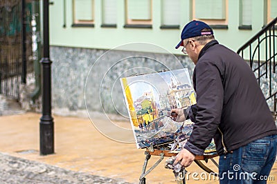 Elderly artist paints a picture of oil in Andrew's Descent Editorial Stock Photo