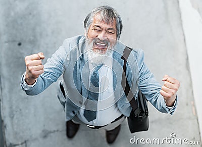Elderly asian business man, celebrate retirement in outdoor building or reach financial investment goal in Seoul. Loan Stock Photo