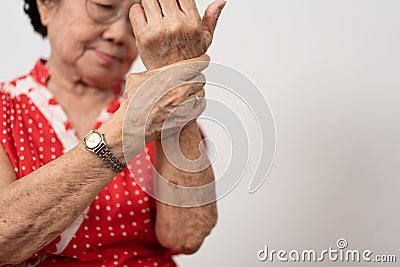 Elderly Asian woman patients suffer from numbing pain in hands from rheumatoid arthritis. Senior woman massage her hand with wrist Stock Photo