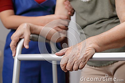 Elderly asian woman using a walker at home with daughter take ca Stock Photo