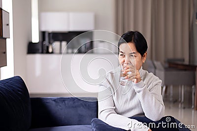 Elderly asian woman drinking water at home in the morning,Happy and smiling,Senior healthy care concept Stock Photo