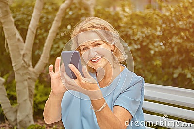 Elderly attractive woman with smartphone outdoor Stock Photo