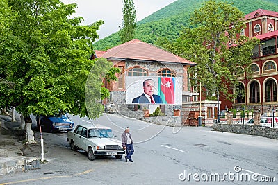 Tired elderly taxi driver waiting for passengers next to his retro soviet car in ancient small town Sheki in Azerbaijan. Editorial Stock Photo