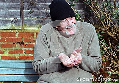 Elderly Beggar holding out both hand. Stock Photo