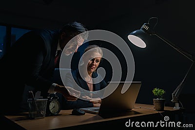 An elderly business man is advising company employees at the office during overtime , Two businessmen are discussing and solving Stock Photo