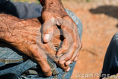 Elderly callous hands of a Latin man resting one upon the other Stock Photo