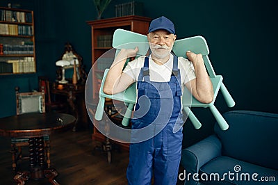 Elderly cargo man in uniform holds child chairs Stock Photo