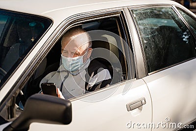 Elderly caucasian man sitting in car and using phone. active modern pension people Stock Photo
