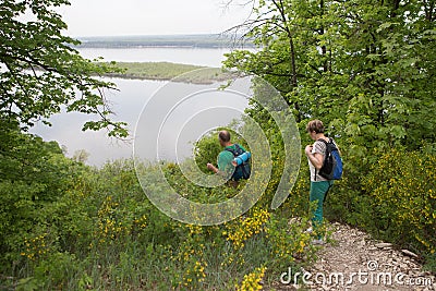 Elderly couple with backpacks travels around mountains. Stock Photo