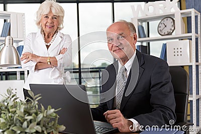 Elderly couple in bureau Stock Photo