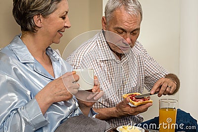 Elderly couple eating romantic breakfast in bed Stock Photo