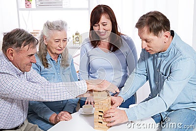 Elderly couple with family Closeup making a pyramid with empty wooden cubes close up Stock Photo