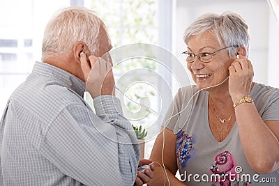 Elderly couple listening to music on mp3 player Stock Photo