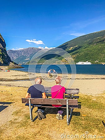 Elderly couple sitting on the bench and enjoying the view on a fjord Editorial Stock Photo