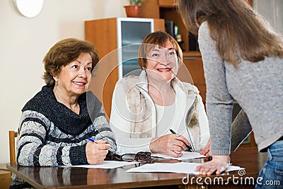 Elderly cute positive women making will at public notary office Stock Photo