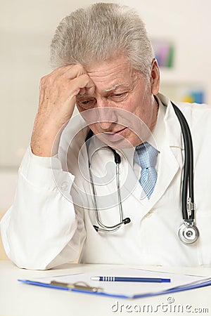 Elderly doctor at a table Stock Photo
