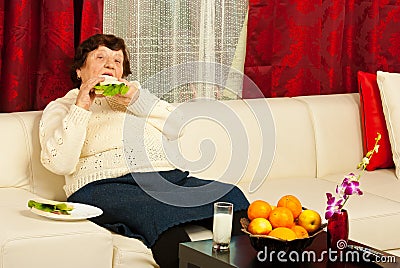 Elderly eating sandwich home Stock Photo