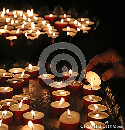 Elderly faithful hand lights a candle Stock Photo