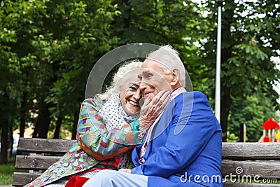 Elderly family couple talking on a bench in a city park. Happy seniors dating Stock Photo