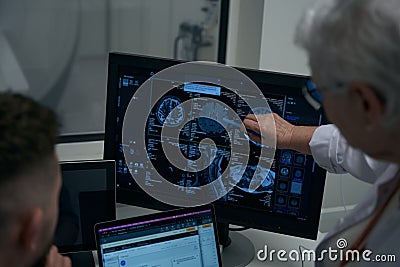 Elderly female doctor and her colleague reviewing brain CT scan results Stock Photo