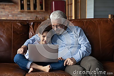 Elderly grandfather and small grandson use laptop Stock Photo