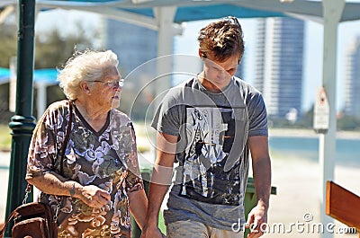 Elderly grandmother day out seaside with grandson walking beach Stock Photo